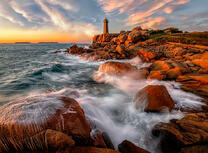 Маяк на красных скалах у моря